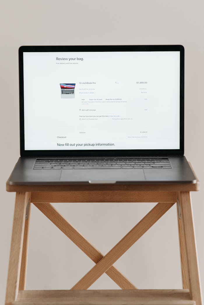 Open laptop displaying checkout screen on a wooden stand, ideal for e-commerce themes.